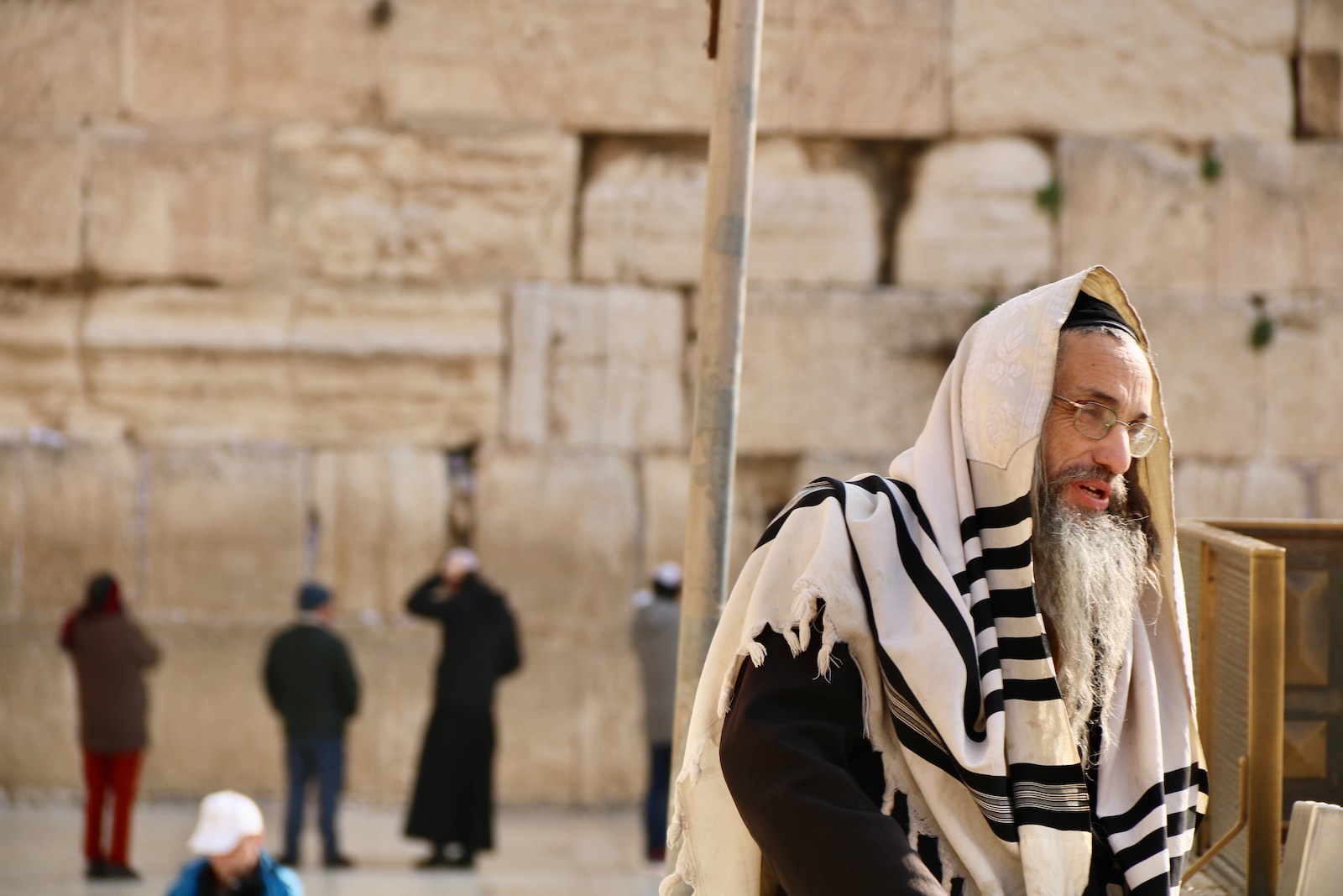 man in prayer shawl standing near people during daytime